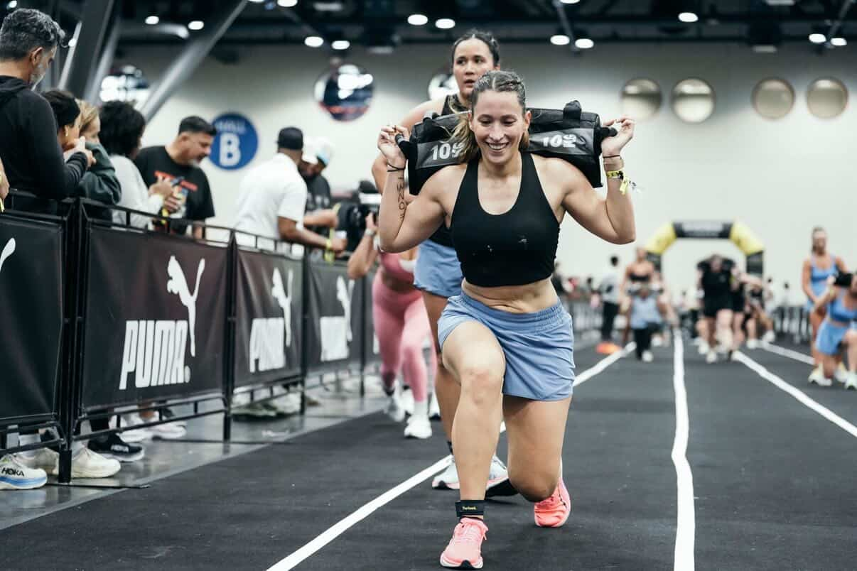 Member lunging with sandbag at HYROX event
